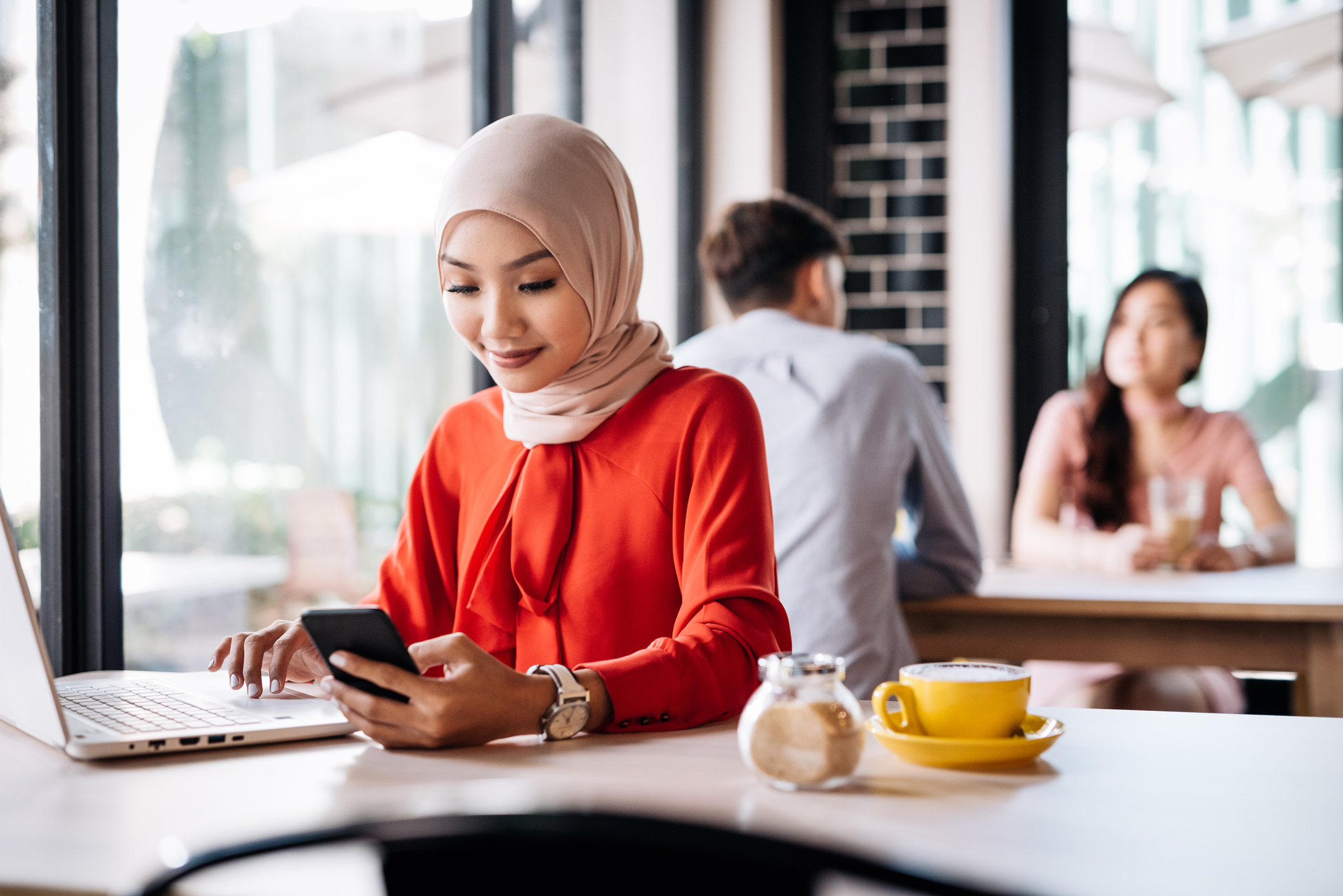 Malaysian woman with hijab sitting in cafe